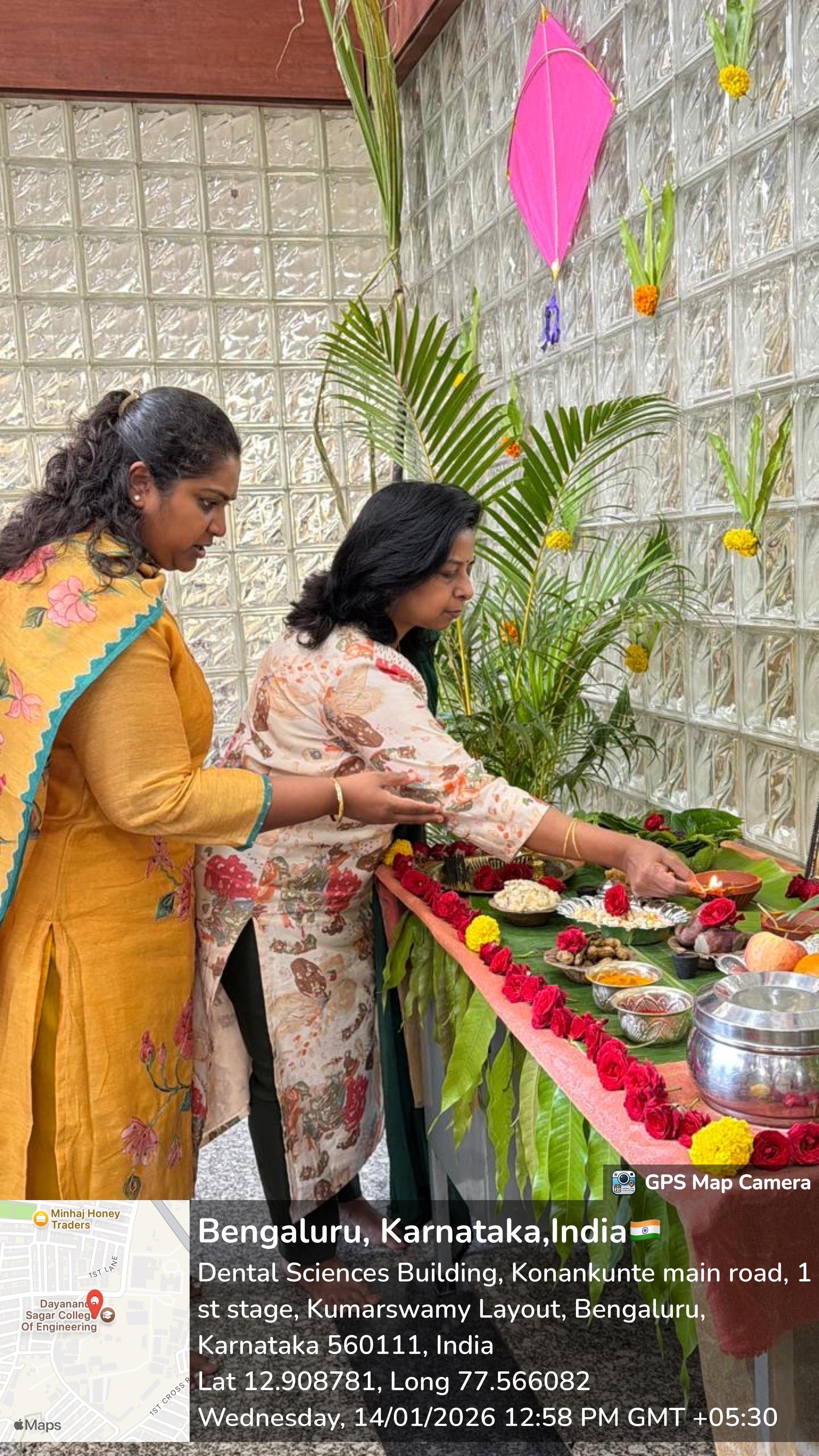 Two women lighting a traditional lamp during the Makara Sankranti celebration