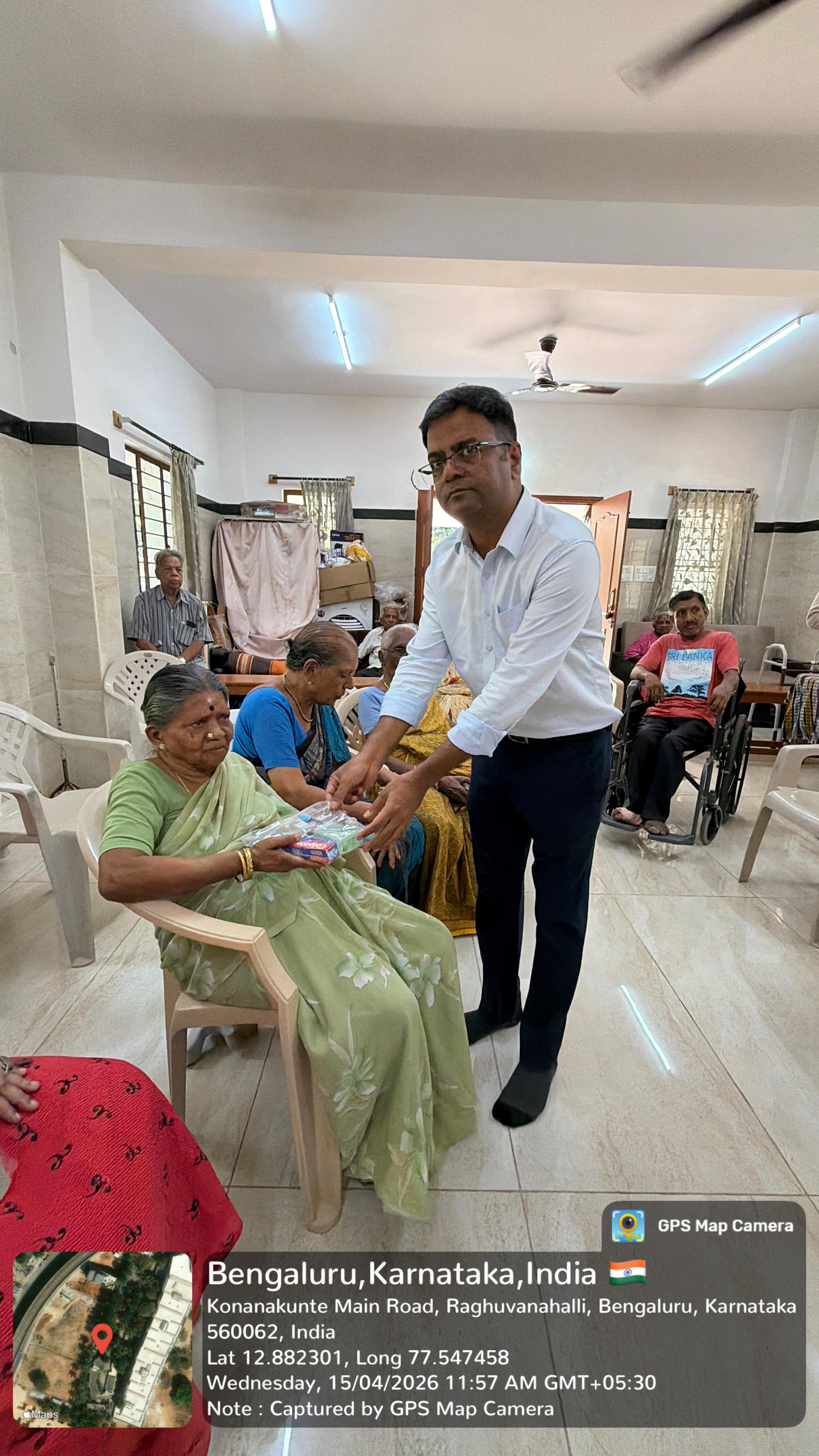 Volunteer distributing hygiene kits to an elderly man in a wheelchair