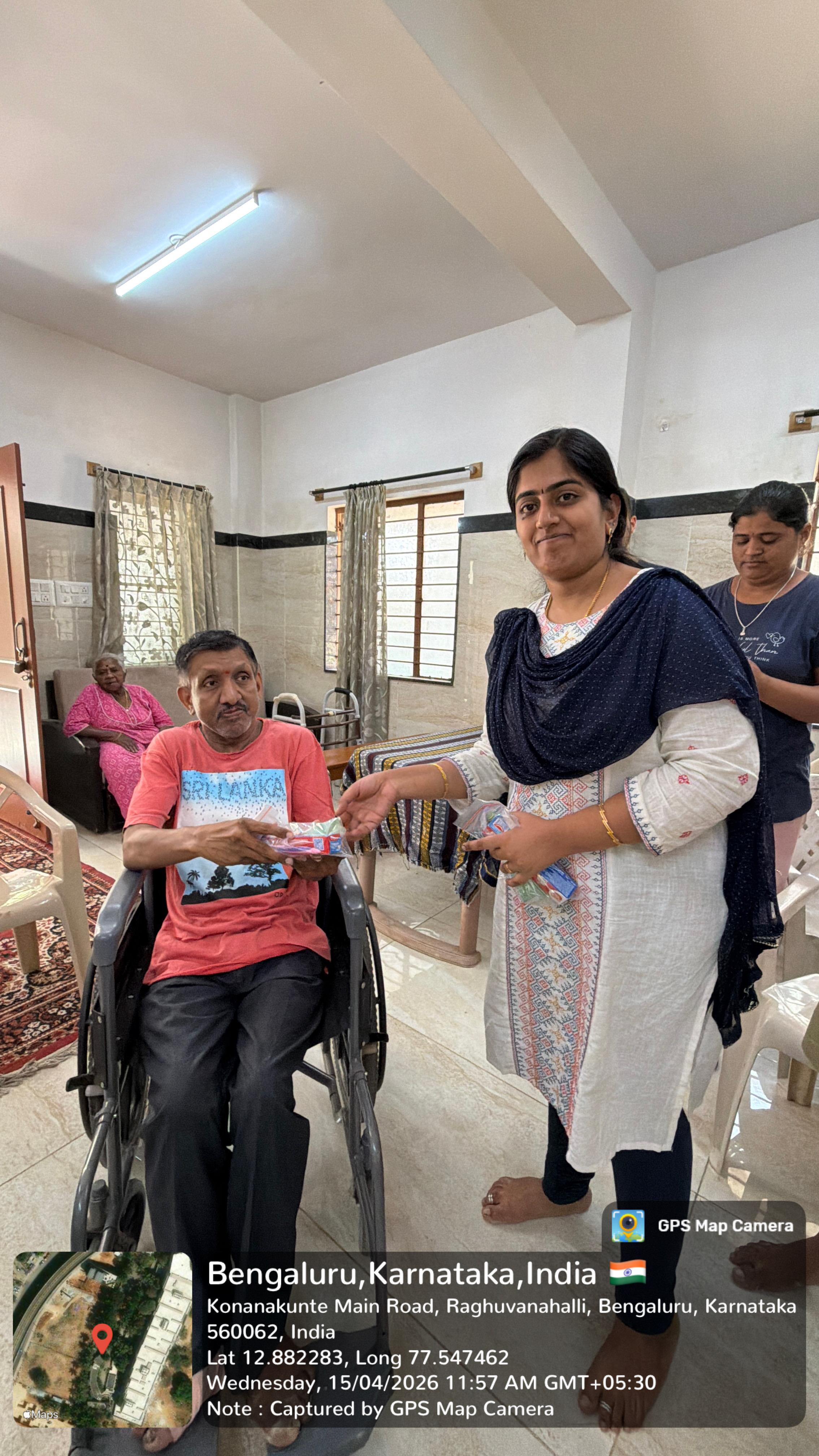 Volunteer distributing hygiene kits to an elderly woman on a couch