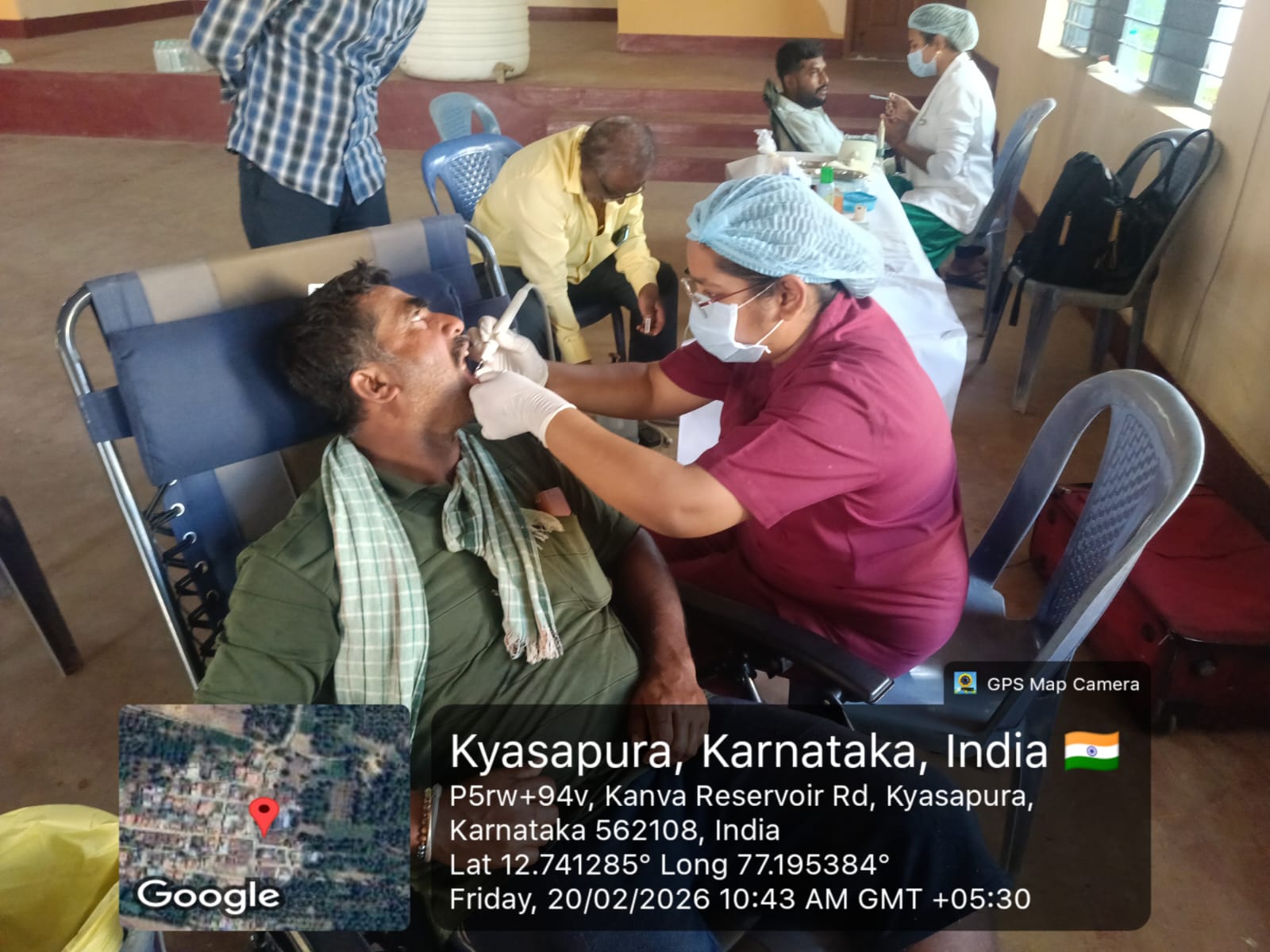 Dentist performing oral prophylaxis on a male patient in a camp setting