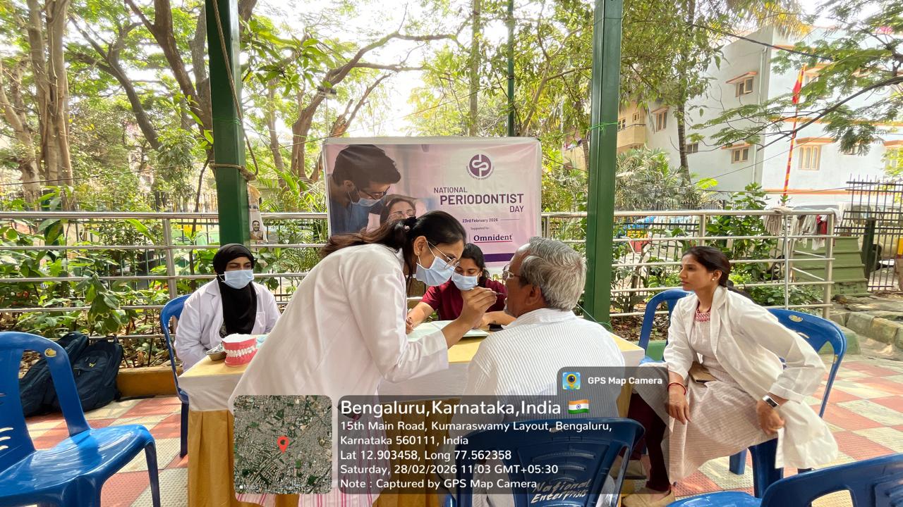 Dental team members at a screening table with patients waiting