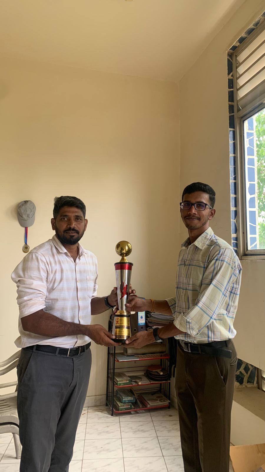 Cricket players and an umpire posing with a trophy