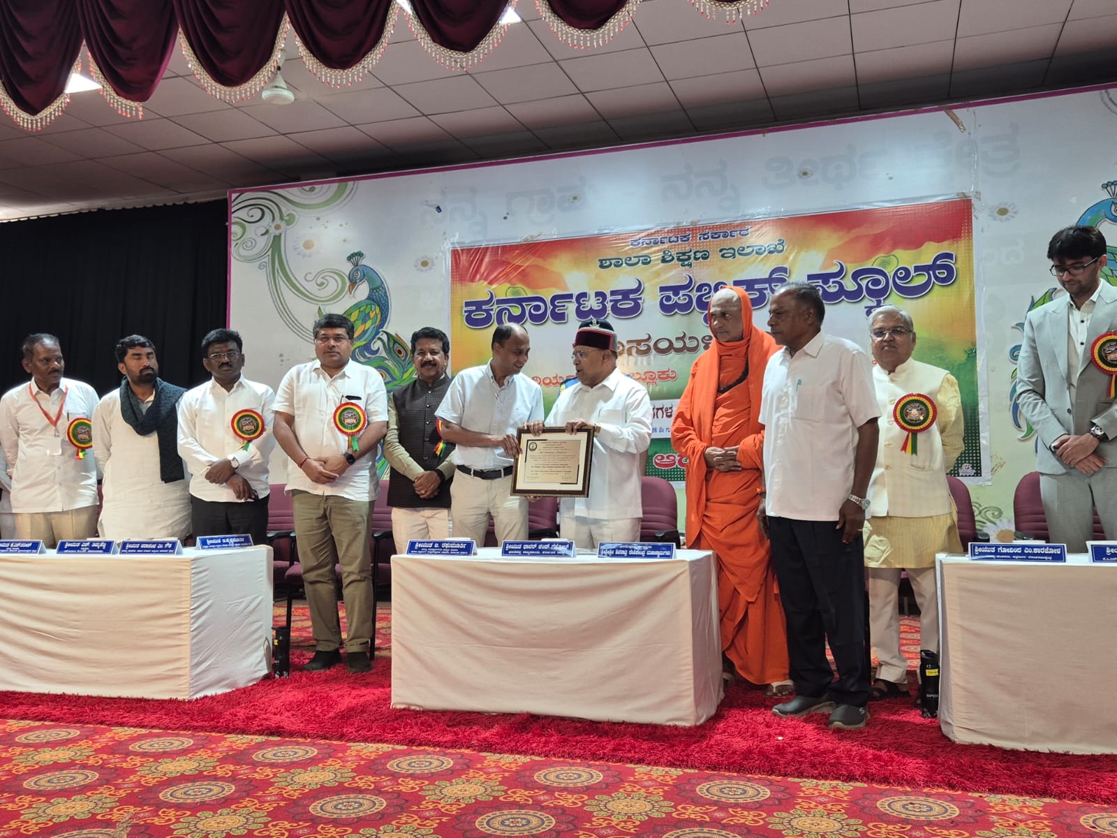 Dignitaries on stage during the certificate presentation ceremony at Karnataka Public School, Hosayelenadu, Hiryur