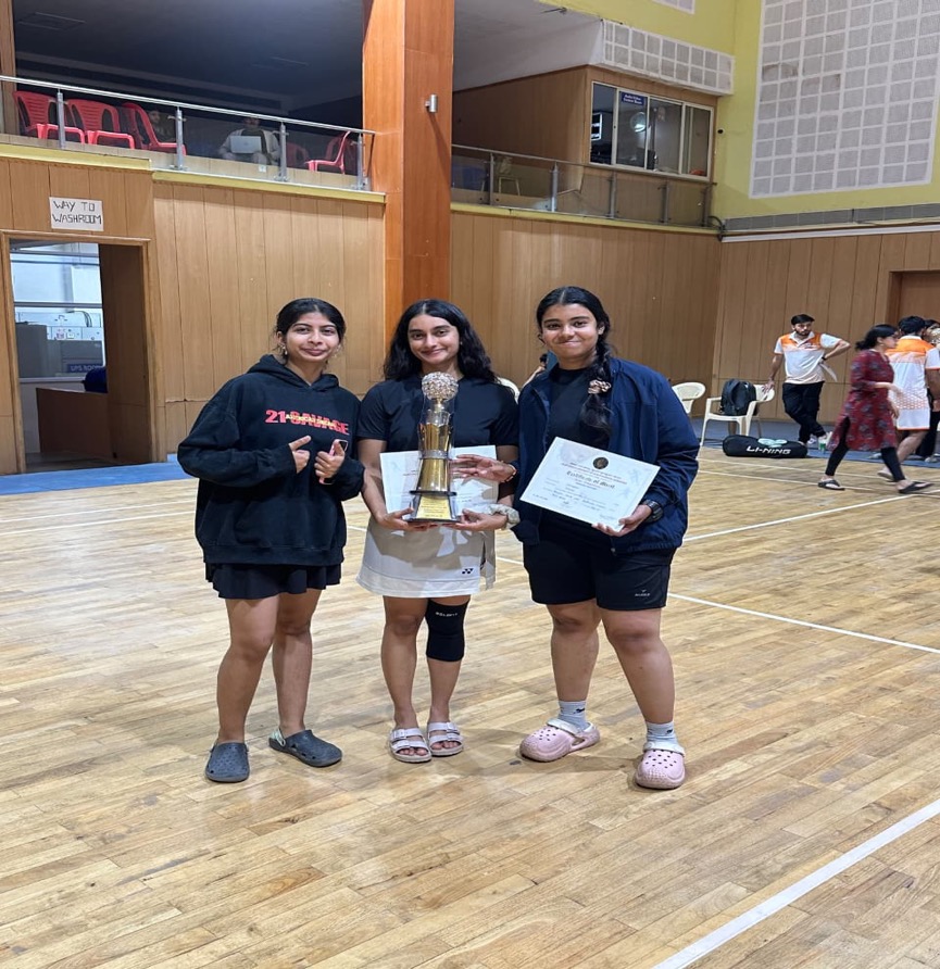 DSCDS Women's Badminton team holding tournament trophy and merit certificates on court